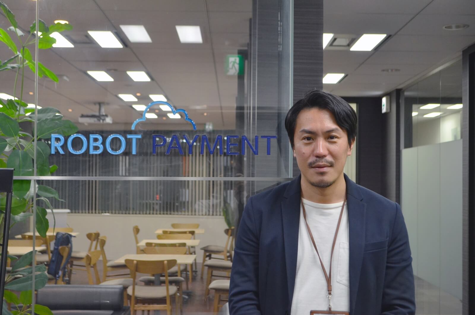 ロボットペイメントのロゴと小倉氏